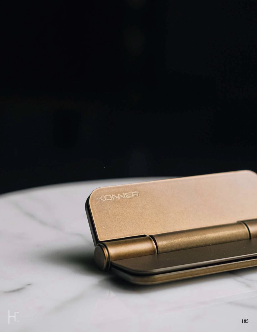 Brass Konner concealed hinge on a marble surface