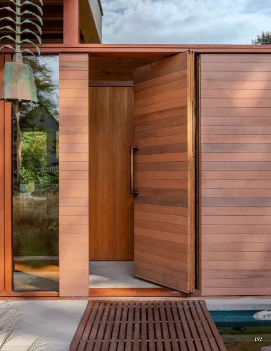 Timber pivot door opening onto a garden