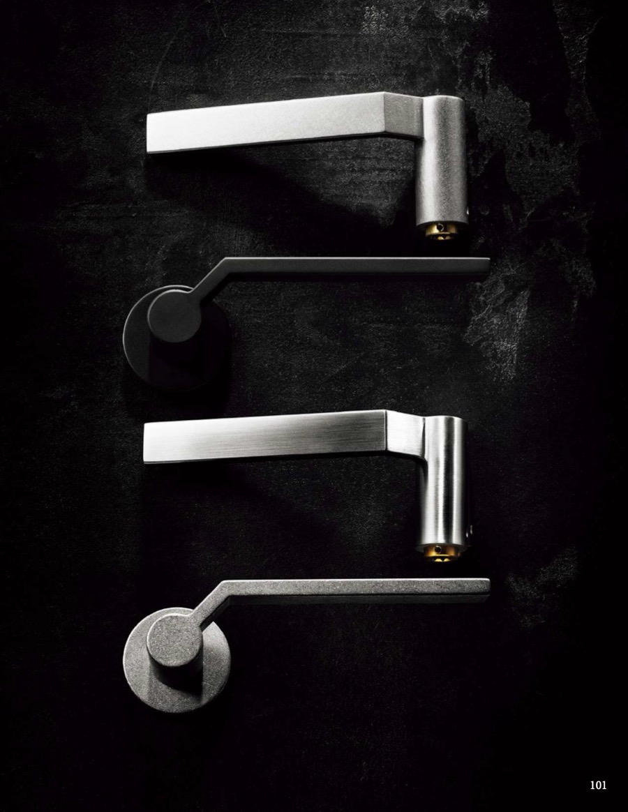 Stainless steel lever handles laid out on a dark surface